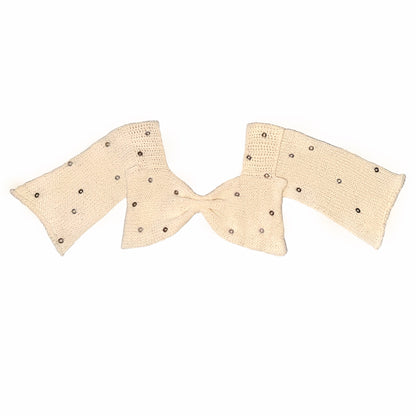 Handmade cream knit bow top with eyelet embellishments by Bailey Prado, photographed on a white background.