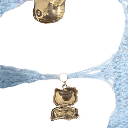 Close-up of the working Hello Kitty locket charms and handcrafted crochet detailing on the Bailey Prado Kitty Locket Top.