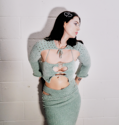 Model wearing the Bailey Prado Sea Green Velvet Top, a handcrafted sea green velvet crochet halter with a rhinestone buckle and pearl embellishments.