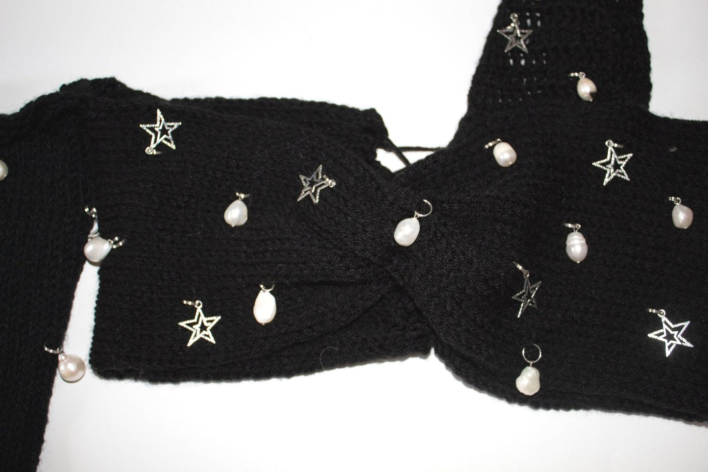 Close-up of the freshwater pearl embellishments, silver star charms, black crochet texture, and adjustable lace-up back on the Bailey Prado Starlight Charm Top.