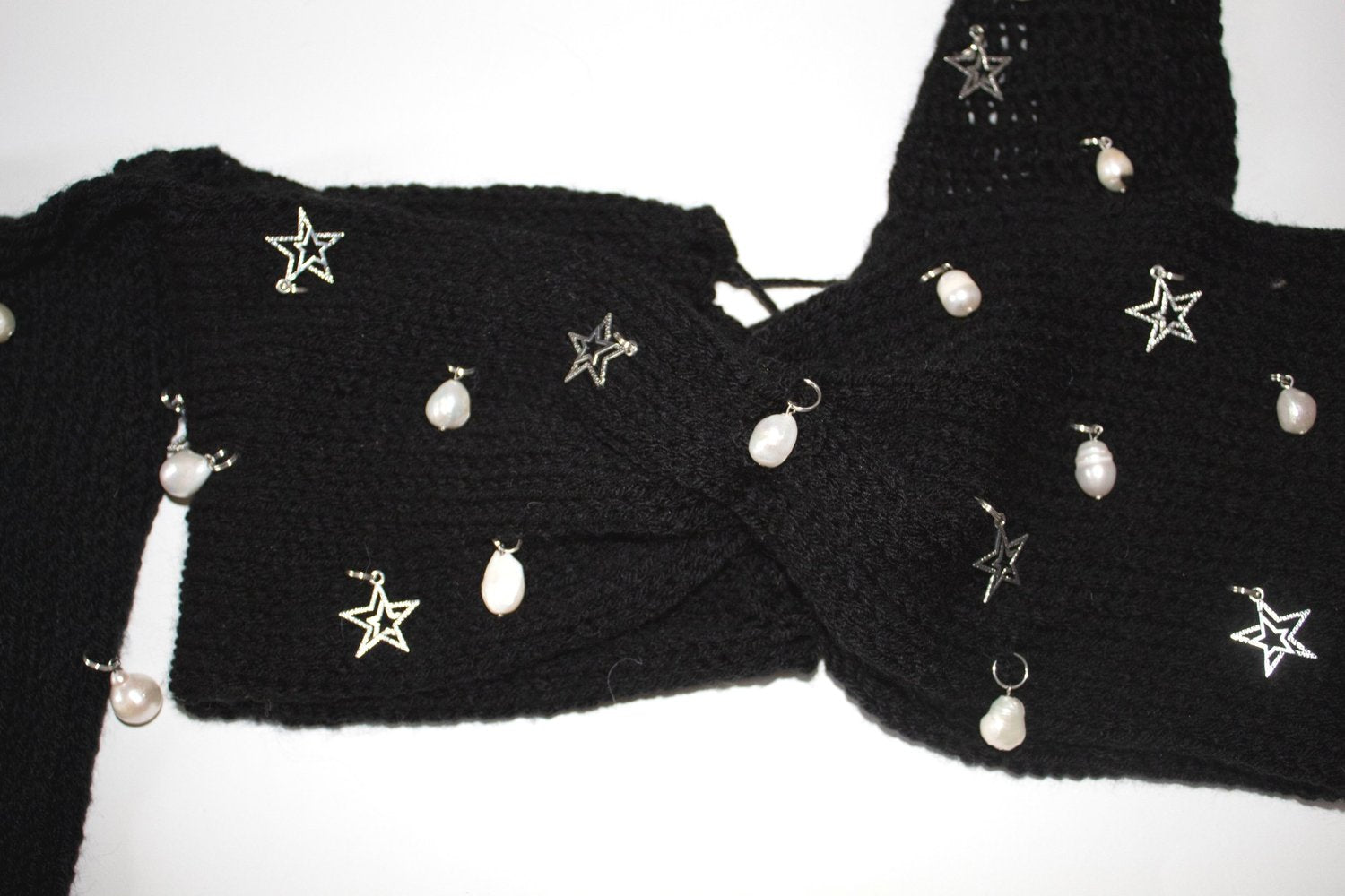 Close-up of the freshwater pearl embellishments, silver star charms, black crochet texture, and adjustable lace-up back on the Bailey Prado Starlight Charm Top.