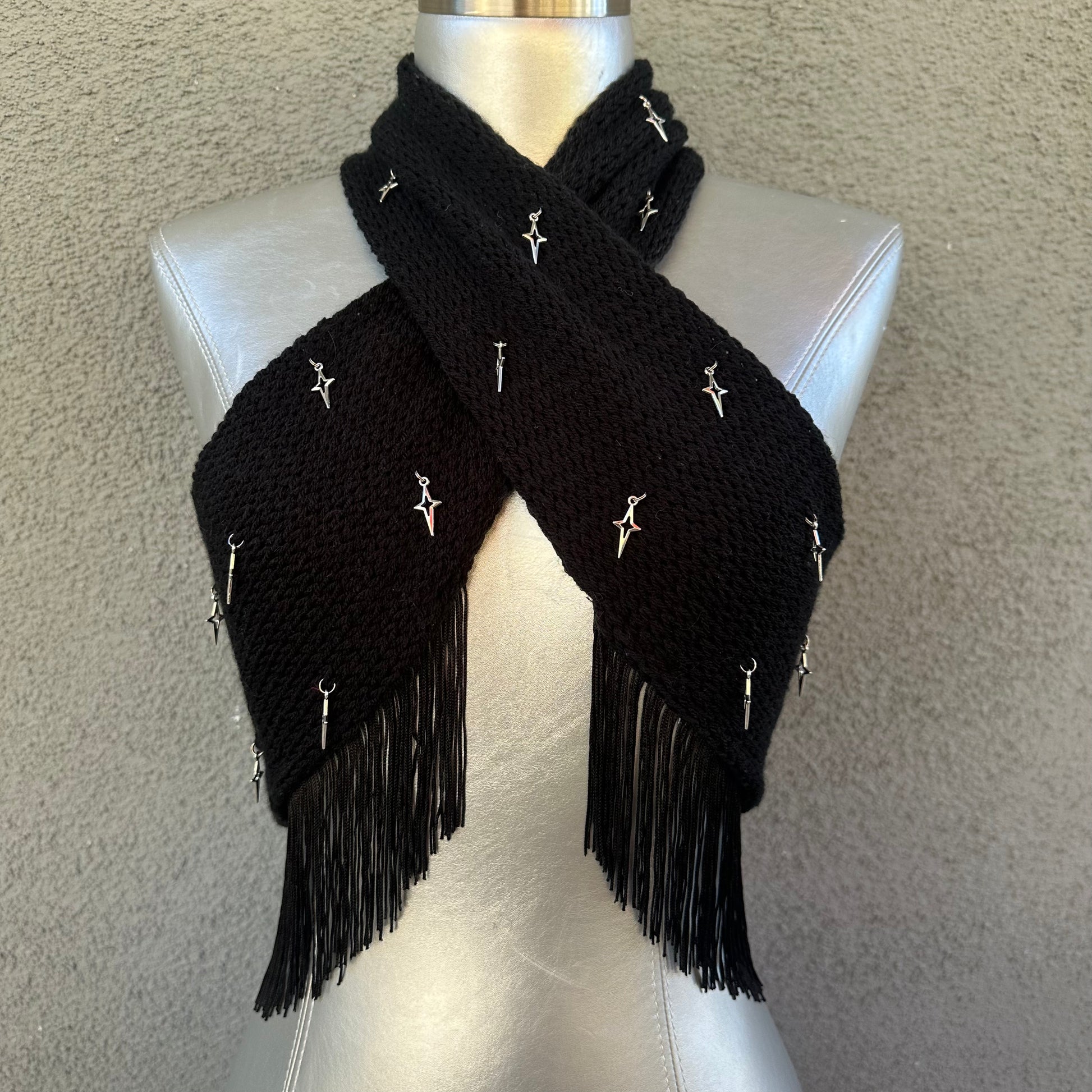 Black wrap-over halter neck top with silver star charm embellishments and tassel trim by Bailey Prado.