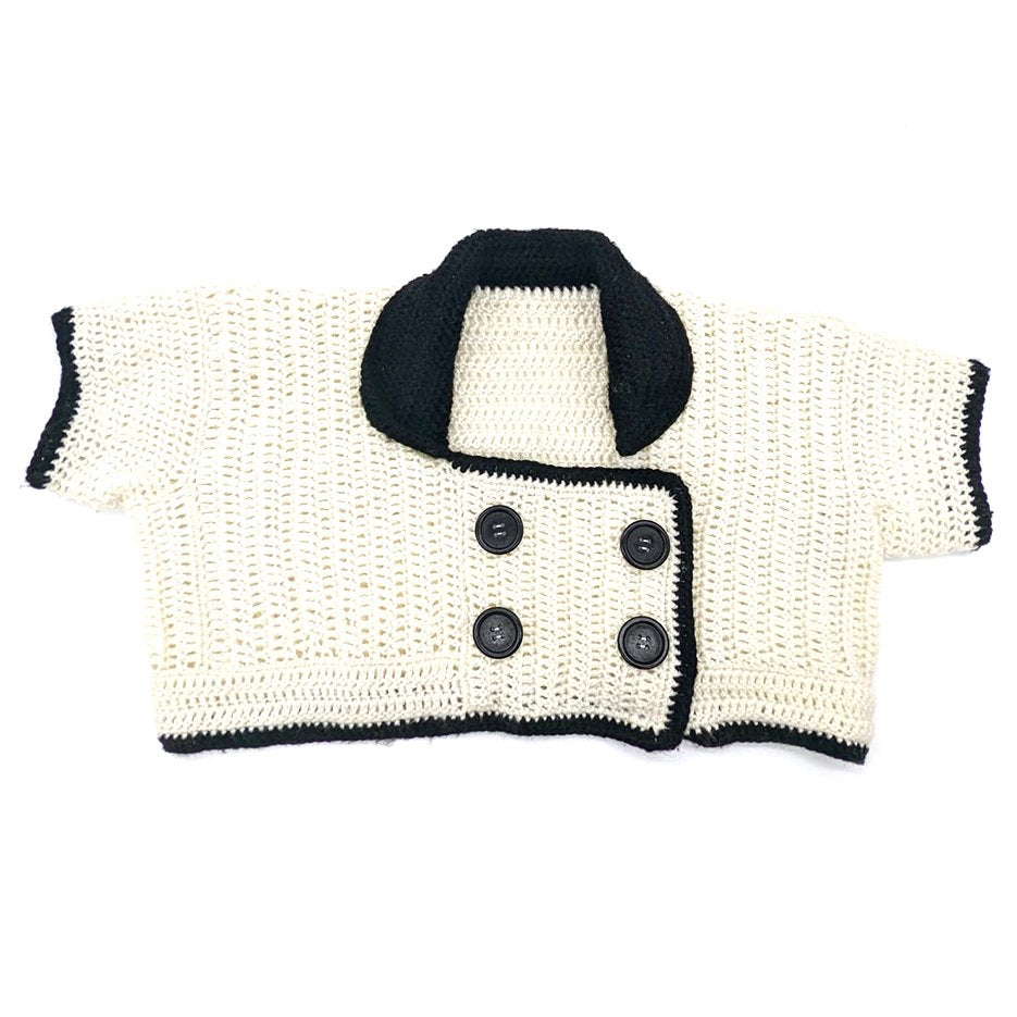 Hand-crocheted black and white cropped cardigan with an oversized collar and double-breasted button closure by Bailey Prado.