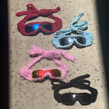 Handmade knitted sunnies by Bailey Prado featuring UV400 protective lenses, available in red, black, pink, and blue.