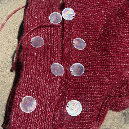 Close-up of handmade knit fabric and shell embellishments on the Bailey Prado Seashell Set.